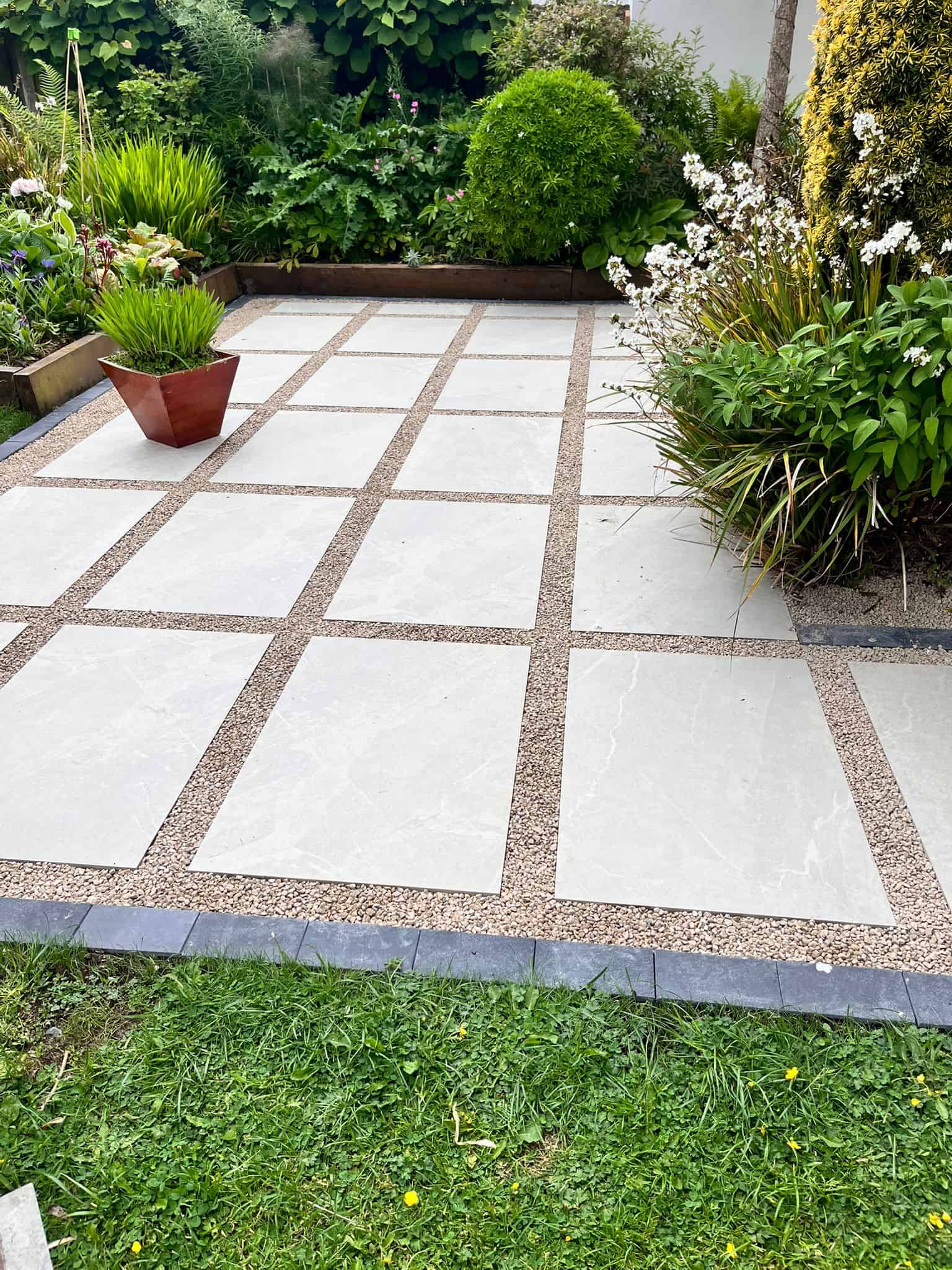 Finished 4Greenfields patio with large-format porcelain slabs and gravel border